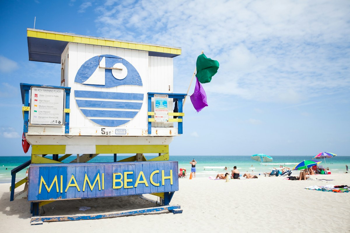 People enjoying the sand and sea at Miami Beach